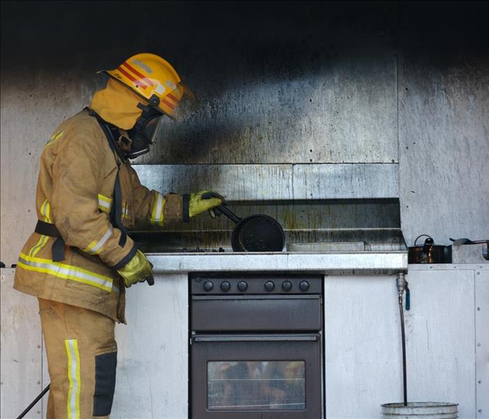 fireman holding pan over burnt stove